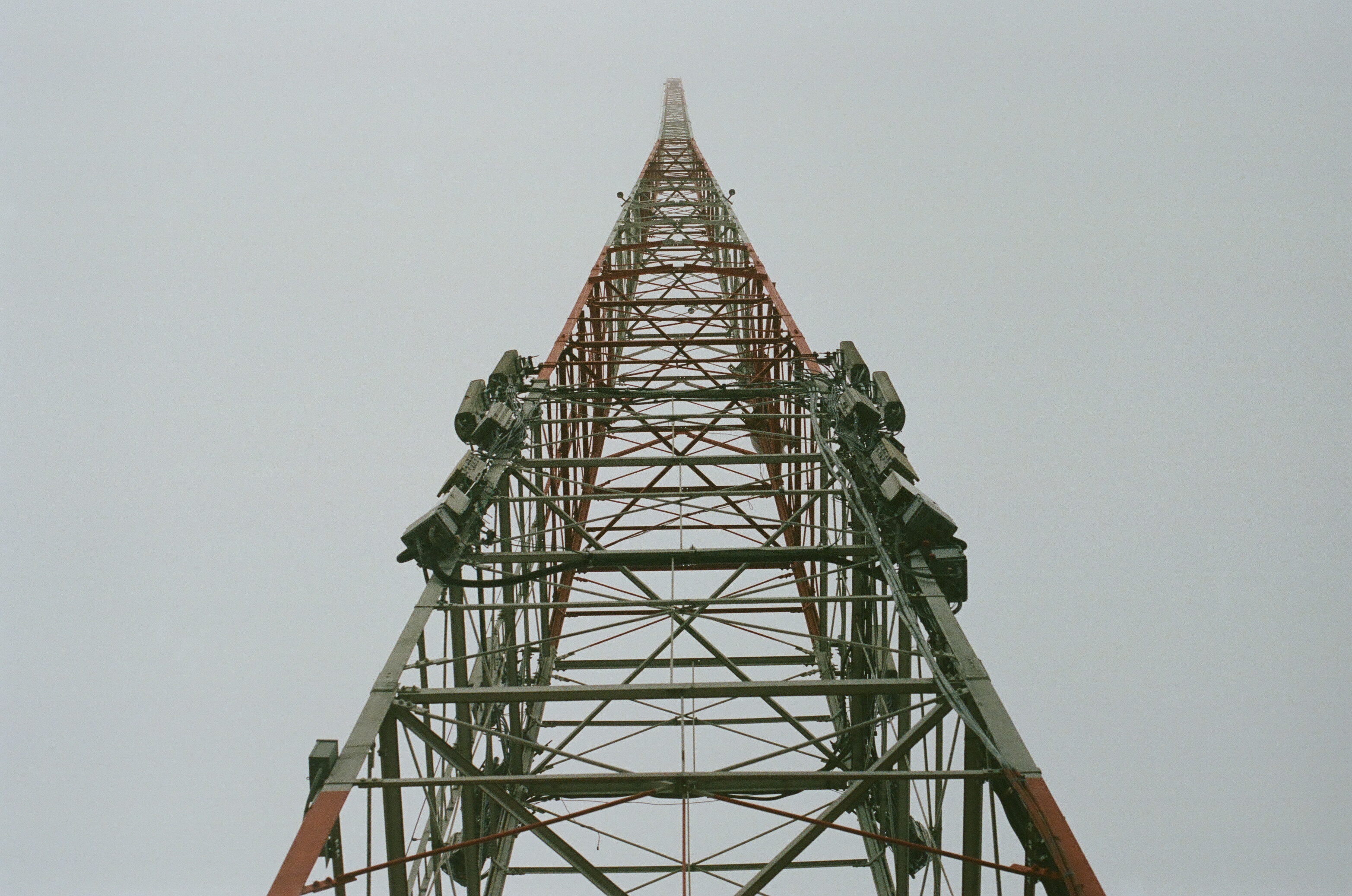 we are looking up at a very large metal radiotower as it extends into the mysterious fog
